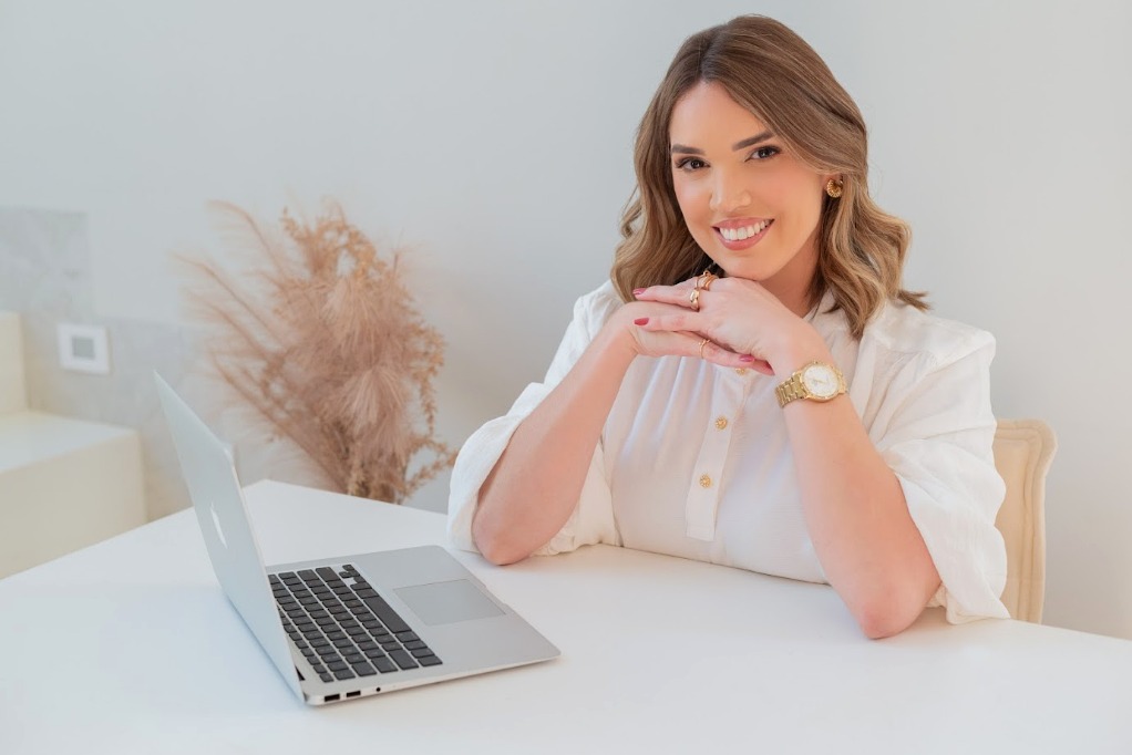 Ana Tolomeu em atendimento com notebook em ambiente claro